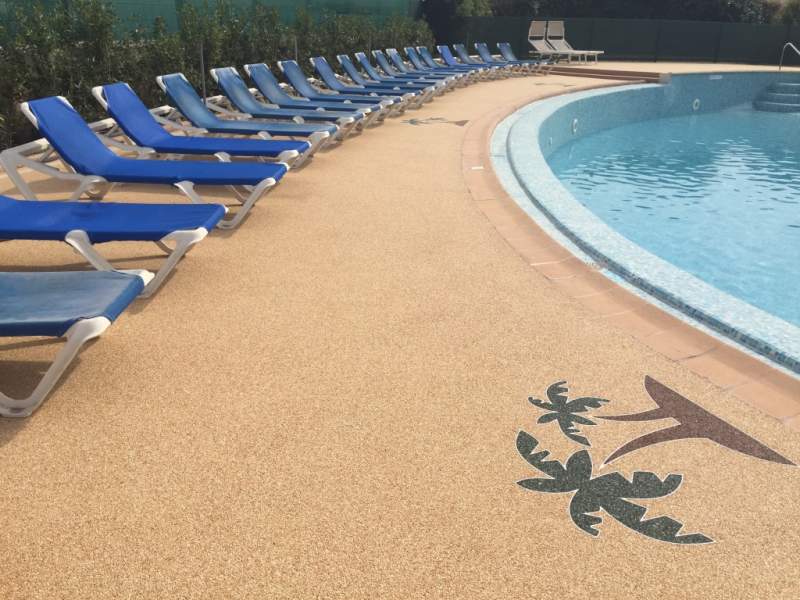Motif palmier réalisé sur une plage de piscine en résine Marbreline réalisé par Instant Résine